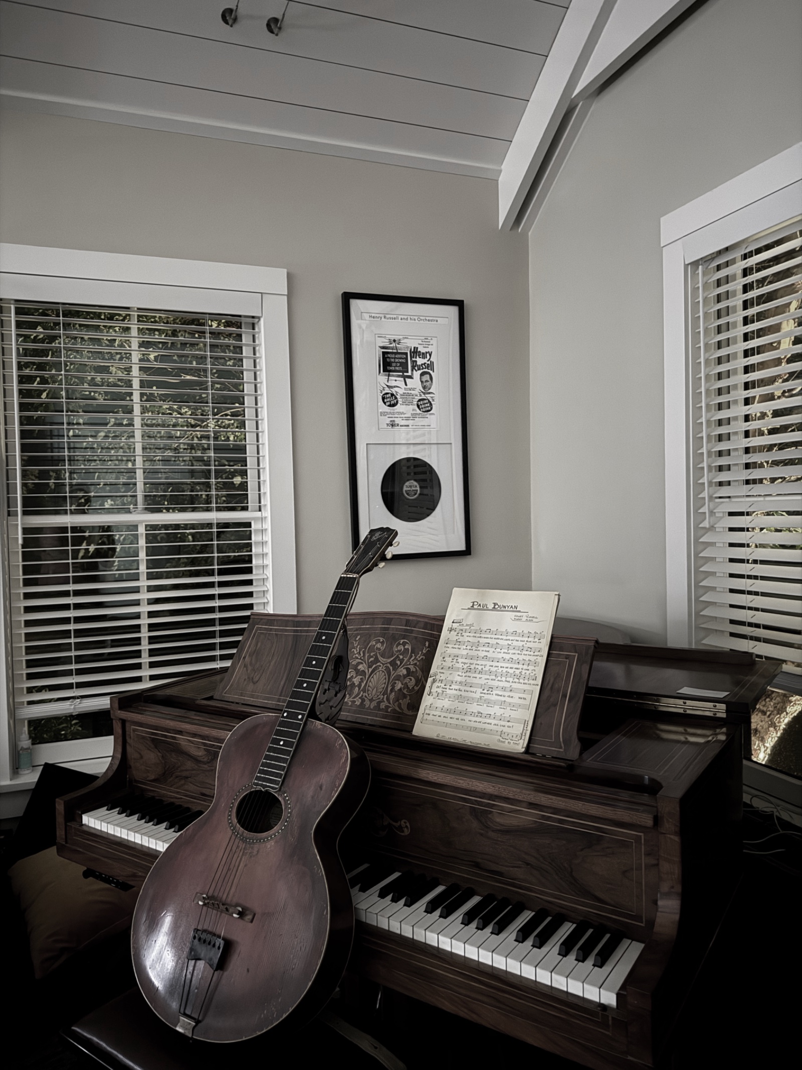 Vintage guitar resting on a piano